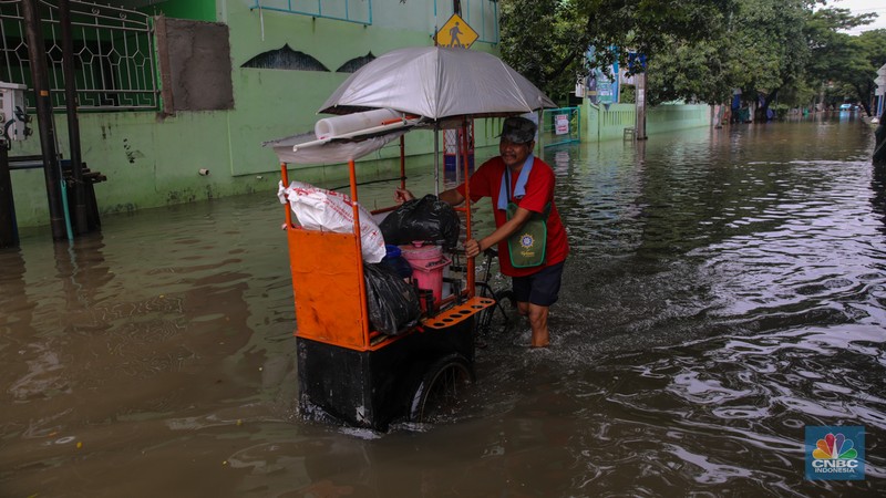 Sejumlah pengendara sepeda motor menerobos banjir yang melanda kawasan Jalan Inspeksi, Jakarta Utara, Kamis (29/1/2026). (CNBC Indonesia/Faisal Rahman)