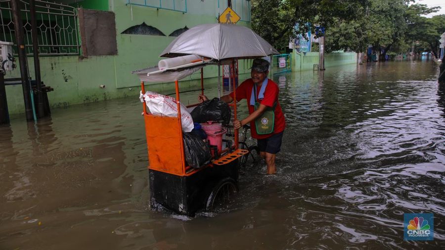 Sejumlah pengendara sepeda motor menerobos banjir yang melanda kawasan Jalan Inspeksi, Jakarta Utara, Kamis (29/1/2026). (CNBC Indonesia/Faisal Rahman)