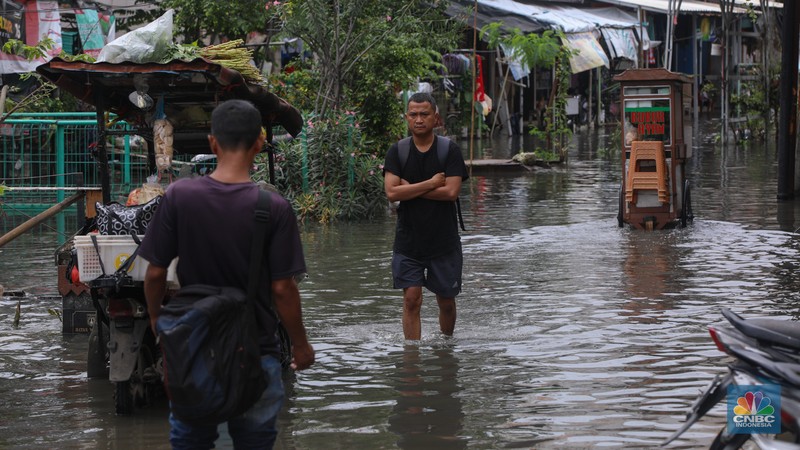 Sejumlah pengendara sepeda motor menerobos banjir yang melanda kawasan Jalan Inspeksi, Jakarta Utara, Kamis (29/1/2026). (CNBC Indonesia/Faisal Rahman)