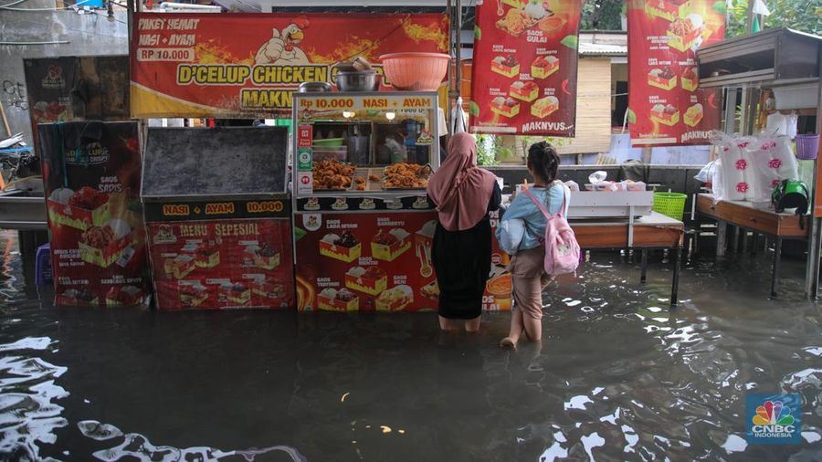 Sejumlah pengendara sepeda motor menerobos banjir yang melanda kawasan Jalan Inspeksi, Jakarta Utara, Kamis (29/1/2026). (CNBC Indonesia/Faisal Rahman)