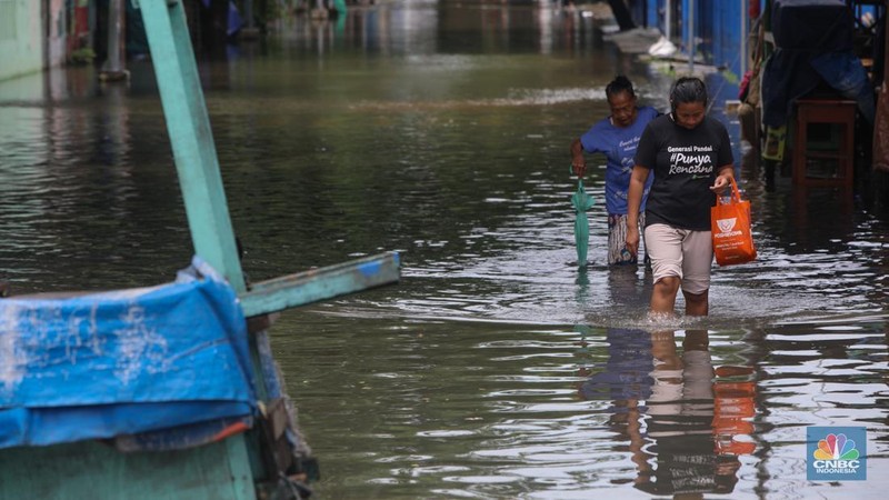 Sejumlah pengendara sepeda motor menerobos banjir yang melanda kawasan Jalan Inspeksi, Jakarta Utara, Kamis (29/1/2026). (CNBC Indonesia/Faisal Rahman)