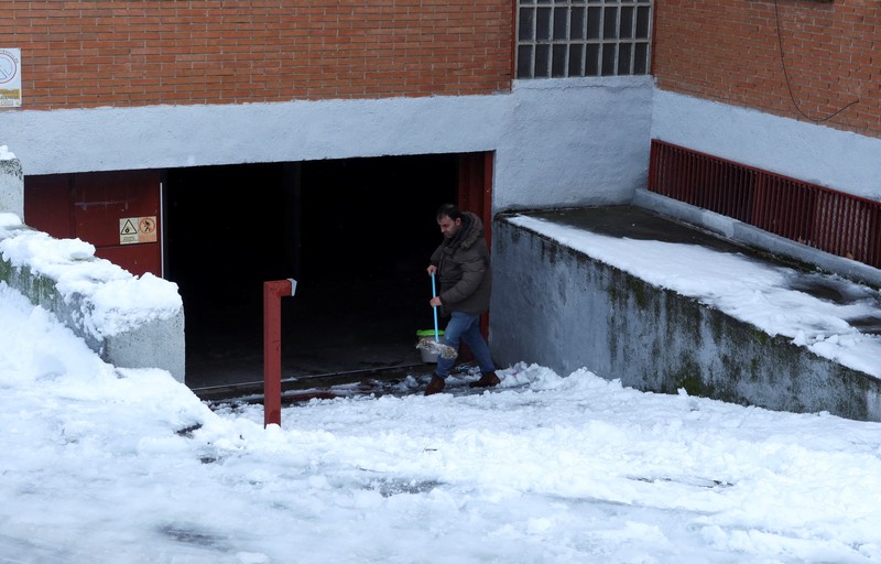 Orang-orang berjalan di jalanan yang tertutup salju saat badai Kristin melanda beberapa bagian Spanyol dan Portugal, di Galapagos, pinggiran Madrid, Spanyol, Rabu (28/1/2026). (REUTERS/Silvio Castellanos)