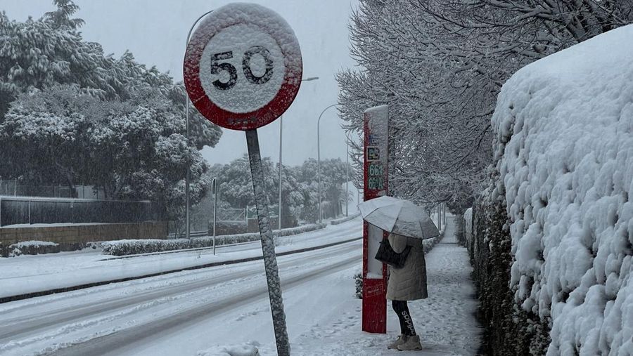 Orang-orang berjalan di jalanan yang tertutup salju saat badai Kristin melanda beberapa bagian Spanyol dan Portugal, di Galapagos, pinggiran Madrid, Spanyol, Rabu (28/1/2026). (REUTERS/Silvio Castellanos)
