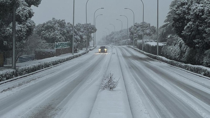 Orang-orang berjalan di jalanan yang tertutup salju saat badai Kristin melanda beberapa bagian Spanyol dan Portugal, di Galapagos, pinggiran Madrid, Spanyol, Rabu (28/1/2026). (REUTERS/Silvio Castellanos)
