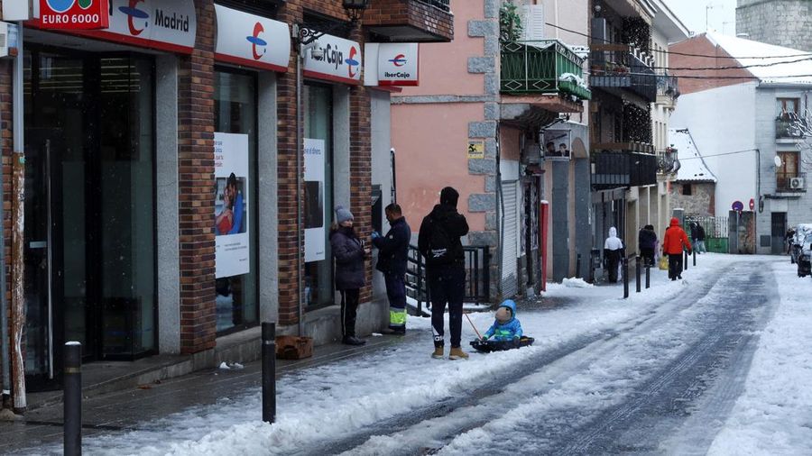 Orang-orang berjalan di jalanan yang tertutup salju saat badai Kristin melanda beberapa bagian Spanyol dan Portugal, di Galapagos, pinggiran Madrid, Spanyol, Rabu (28/1/2026). (REUTERS/Silvio Castellanos)