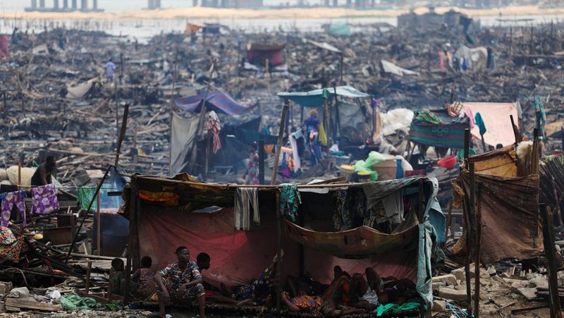 Warga beristirahat di dalam tempat penampungan darurat sementara pihak berwenang membakar bangunan yang tersisa di komunitas tepi sungai Makoko di Lagos, Nigeria, 25 Januari 2026. (REUTERS/Sodiq Adelakun)