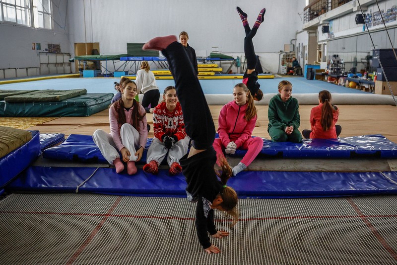 Gadis-gadis yang mengenakan kaus kaki hangat dan pakaian musim dingin berlapis-lapis mengikuti latihan kekuatan selama sesi pelatihan di aula senam di Kiev, Ukraina, Kamis (29/1/2026). (REUTERS/Alina Smutko)