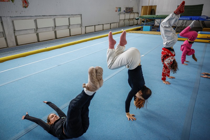 Gadis-gadis yang mengenakan kaus kaki hangat dan pakaian musim dingin berlapis-lapis mengikuti latihan kekuatan selama sesi pelatihan di aula senam di Kiev, Ukraina, Kamis (29/1/2026). (REUTERS/Alina Smutko)