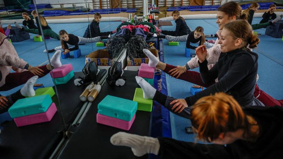 Gadis-gadis yang mengenakan kaus kaki hangat dan pakaian musim dingin berlapis-lapis mengikuti latihan kekuatan selama sesi pelatihan di aula senam di Kiev, Ukraina, Kamis (29/1/2026). (REUTERS/Alina Smutko)