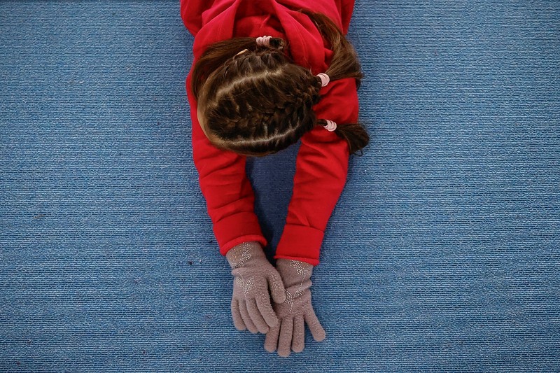 Gadis-gadis yang mengenakan kaus kaki hangat dan pakaian musim dingin berlapis-lapis mengikuti latihan kekuatan selama sesi pelatihan di aula senam di Kiev, Ukraina, Kamis (29/1/2026). (REUTERS/Alina Smutko)