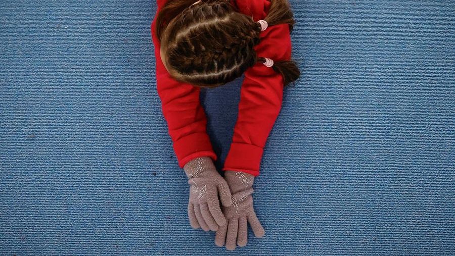 Gadis-gadis yang mengenakan kaus kaki hangat dan pakaian musim dingin berlapis-lapis mengikuti latihan kekuatan selama sesi pelatihan di aula senam di Kiev, Ukraina, Kamis (29/1/2026). (REUTERS/Alina Smutko)