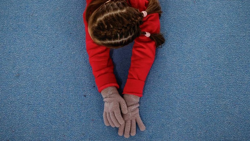 Gadis-gadis yang mengenakan kaus kaki hangat dan pakaian musim dingin berlapis-lapis mengikuti latihan kekuatan selama sesi pelatihan di aula senam di Kiev, Ukraina, Kamis (29/1/2026). (REUTERS/Alina Smutko)