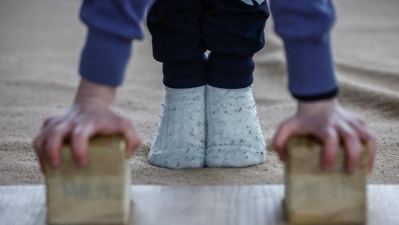 Gadis-gadis yang mengenakan kaus kaki hangat dan pakaian musim dingin berlapis-lapis mengikuti latihan kekuatan selama sesi pelatihan di aula senam di Kiev, Ukraina, Kamis (29/1/2026). (REUTERS/Alina Smutko)