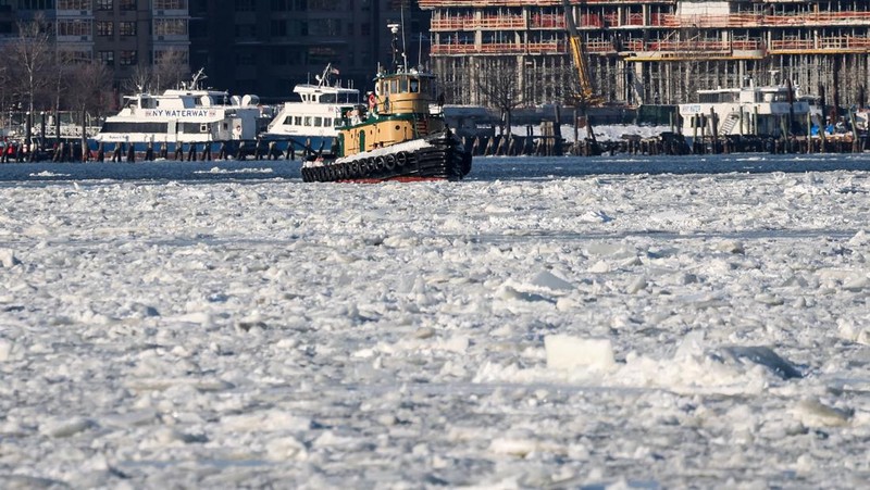 Sebuah kapal tunda berlayar melewati bongkahan es di Sungai Hudson antara New Jersey dan Kota New York, AS, Kamis (29/1/2026). (REUTERS/Brendan McDermid)