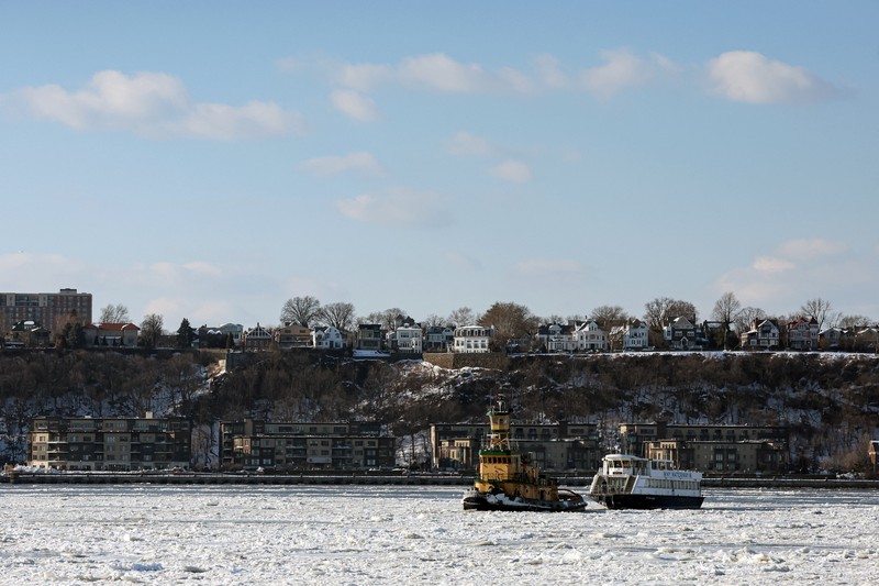 Sebuah kapal tunda berlayar melewati bongkahan es di Sungai Hudson antara New Jersey dan Kota New York, AS, Kamis (29/1/2026). (REUTERS/Brendan McDermid)