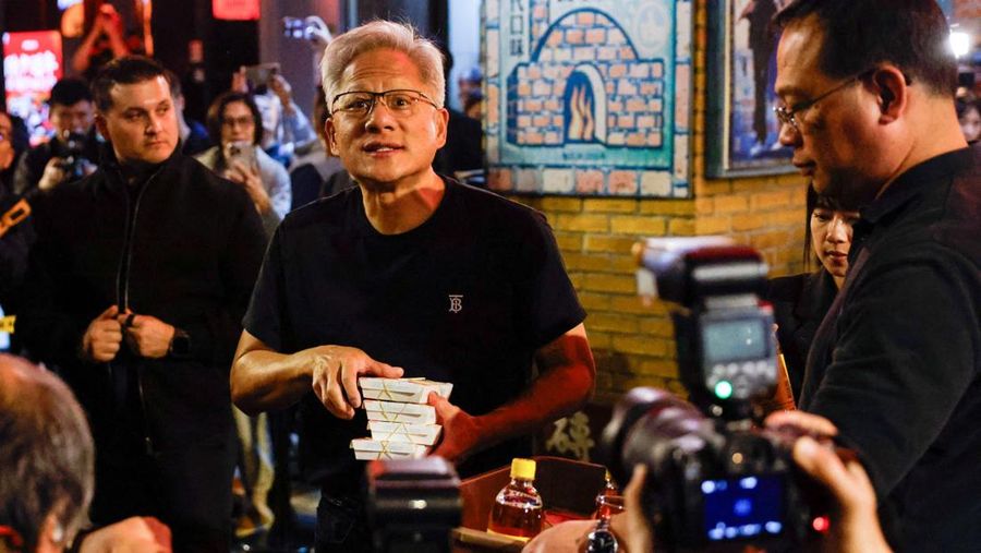 CEO Nvidia Jensen Huang memberikan makanan kepada anggota media sebelum makan malam yang ia selenggarakan bersama para CEO teknologi Taiwan di Taipei, Taiwan, Sabtu (31/1/2026). (REUTERS/Ann Wang)