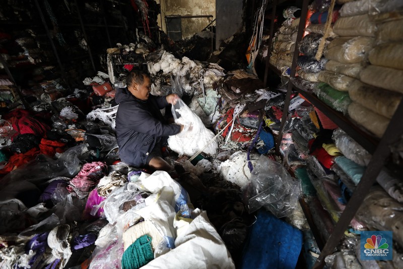 Petugas pemadam kebakaran mendinginkan sisa-sisa api yang masih menyala di Gudang dekorasi dan ruko tekstil di Jalan Pajak Raya, Cipadu, Juramangu Timur, Tangerang Selatan (Tangsel), Senin (2/1/2026). (CNBC Indonesia/Tri Susilo)