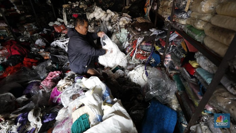 Petugas pemadam kebakaran mendinginkan sisa-sisa api yang masih menyala di Gudang dekorasi dan ruko tekstil di Jalan Pajak Raya, Cipadu, Juramangu Timur, Tangerang Selatan (Tangsel), Senin (2/1/2026). (CNBC Indonesia/Tri Susilo)