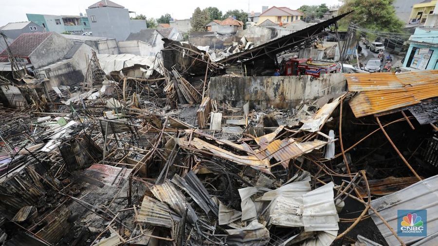 Petugas pemadam kebakaran mendinginkan sisa-sisa api yang masih menyala di Gudang dekorasi dan ruko tekstil di Jalan Pajak Raya, Cipadu, Juramangu Timur, Tangerang Selatan (Tangsel), Senin (2/1/2026). (CNBC Indonesia/Tri Susilo)
