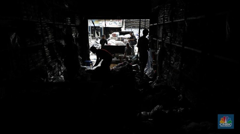 Petugas pemadam kebakaran mendinginkan sisa-sisa api yang masih menyala di Gudang dekorasi dan ruko tekstil di Jalan Pajak Raya, Cipadu, Juramangu Timur, Tangerang Selatan (Tangsel), Senin (2/1/2026). (CNBC Indonesia/Tri Susilo)