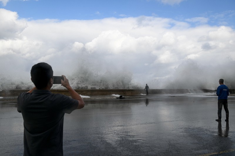 Seseorang berjalan di tepi laut Malecon yang tergenang banjir di Havana, Kuba, 1 Februari 2026. (REUTERS/Norlys Perez)