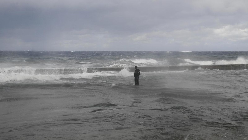 Seseorang berjalan di tepi laut Malecon yang tergenang banjir di Havana, Kuba, 1 Februari 2026. (REUTERS/Norlys Perez)