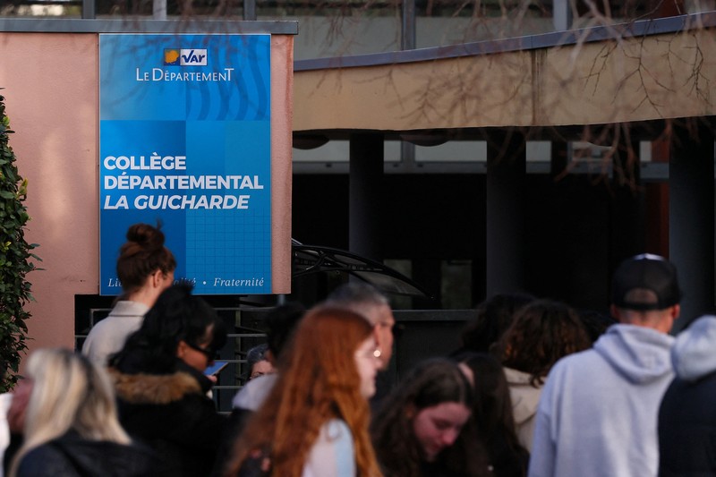 Polisi Prancis, siswa, dan orang tua berdiri di depan sekolah menengah La Guicharde setelah seorang guru seni mengalami luka serius akibat ditikam oleh seorang murid berusia 14 tahun, di Sanary-sur-Mer dekat Toulon, di Prancis selatan, 3 Februari 2026. (REUTERS/Manon Cruz)