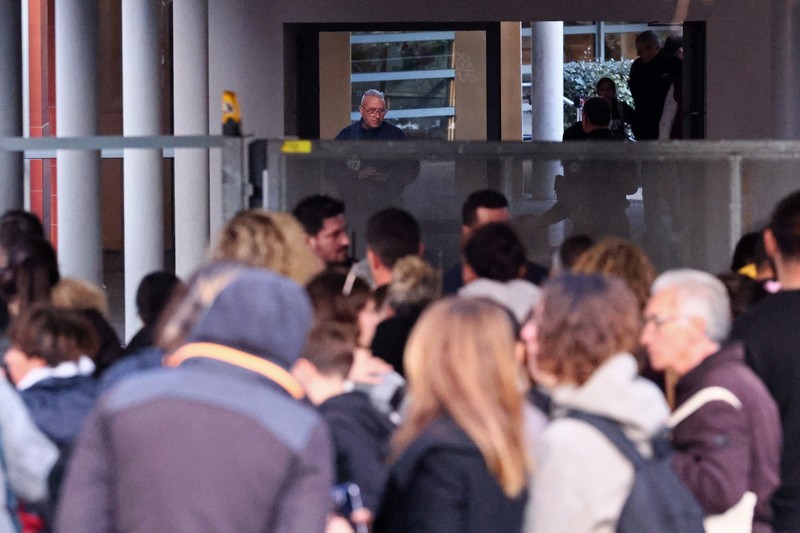 Polisi Prancis, siswa, dan orang tua berdiri di depan sekolah menengah La Guicharde setelah seorang guru seni mengalami luka serius akibat ditikam oleh seorang murid berusia 14 tahun, di Sanary-sur-Mer dekat Toulon, di Prancis selatan, 3 Februari 2026. (REUTERS/Manon Cruz)