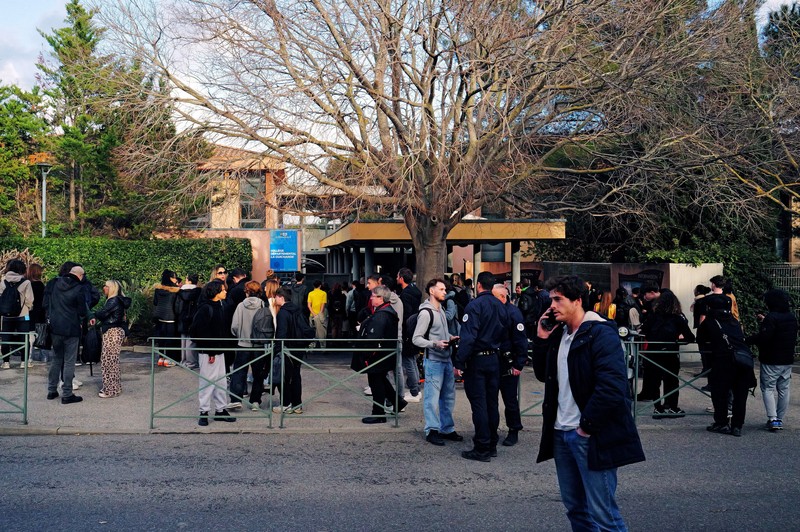 Polisi Prancis, siswa, dan orang tua berdiri di depan sekolah menengah La Guicharde setelah seorang guru seni mengalami luka serius akibat ditikam oleh seorang murid berusia 14 tahun, di Sanary-sur-Mer dekat Toulon, di Prancis selatan, 3 Februari 2026. (REUTERS/Manon Cruz)