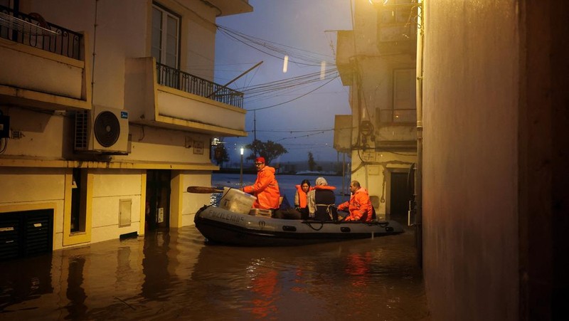 Seorang pria menerobos genangan air untuk mencapai rumahnya saat badai Leo membanjiri jalanan Alcacer do Sal, Portugal, 4 Februari 2026. (REUTERS/Pedro Nunes)