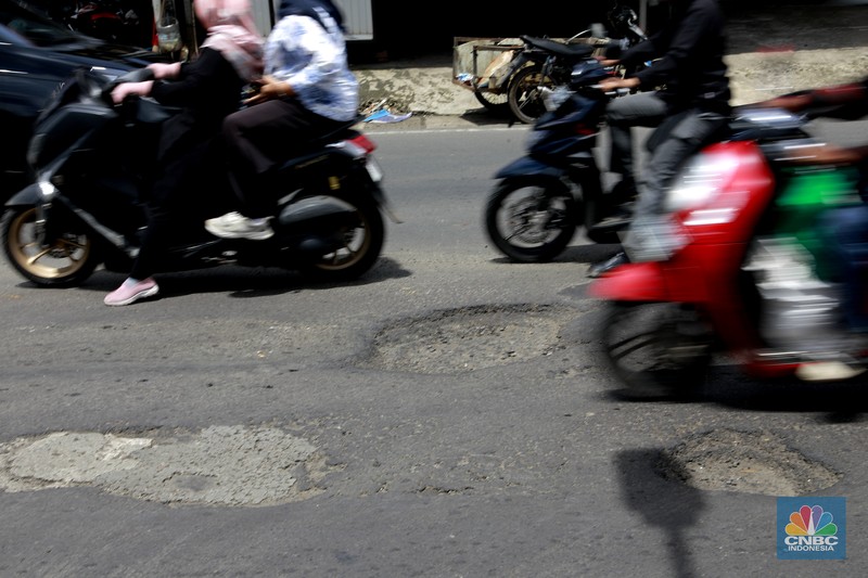 Pengendara mobil roda empat menghindari lobang di Jl raya Moh Toha, Tangeran Selatan, Jumat (6/2/2026). (CNBC Indonesia/Muhammad Sabki)