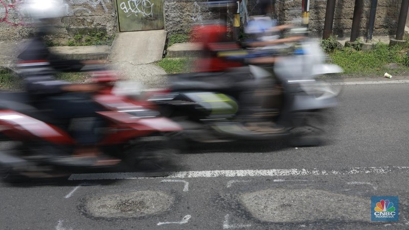 Pengendara mobil roda empat menghindari lobang di Jl raya Moh Toha, Tangeran Selatan, Jumat (6/2/2026). (CNBC Indonesia/Muhammad Sabki)