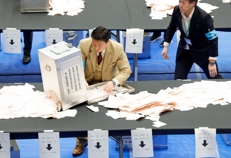 Perdana Menteri Jepang Sanae Takaichi, pemimpin Partai Demokrat Liberal (LDP) yang berkuasa, di samping Sekretaris Jenderal LDP Shunichi Suzuki dan Kepala Strategi Pemilu LDP Keiji Furuya, meletakkan bunga mawar kertas merah di atas nama kandidat terpilih di markas besar LDP pada hari pemilihan umum di Tokyo, Jepang, 8 Februari 2026. (REUTERS/Kim Kyung-Hoon/Pool)