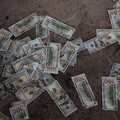 Counterfeit U.S. 100 dollar banknotes on the floor inside a compound in O'Smach used for scam operations, at the Chong Chom-O'Smach border crossing, which was bombed and occupied by the Thai military in December following clashes between Thailand and