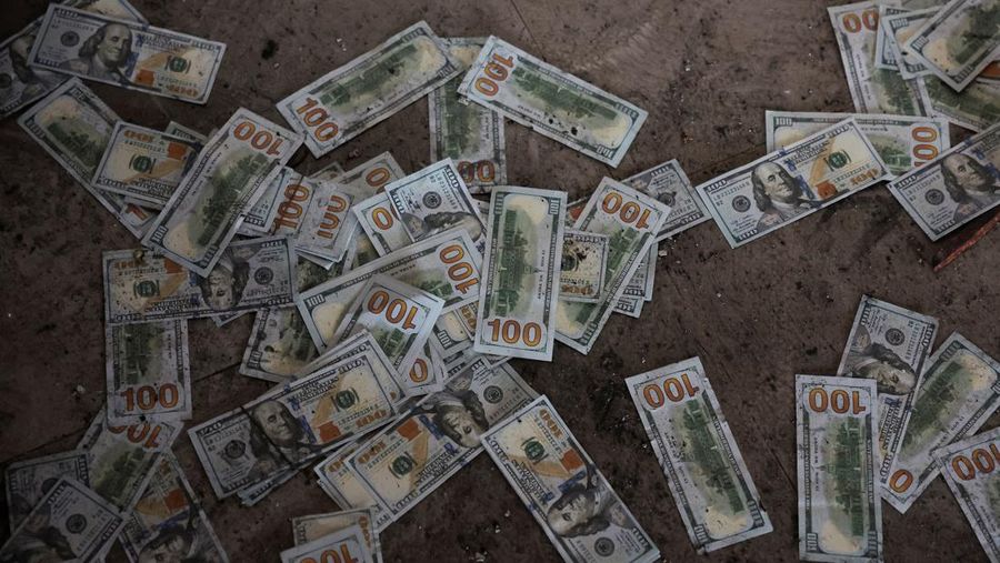 Counterfeit U.S. 100 dollar banknotes on the floor inside a compound in O'Smach used for scam operations, at the Chong Chom-O'Smach border crossing, which was bombed and occupied by the Thai military in December following clashes between Thailand and