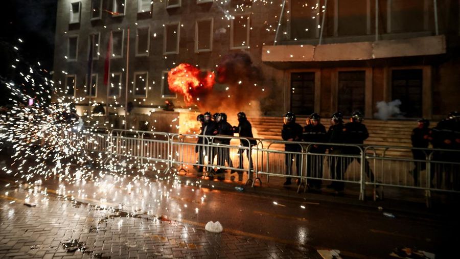 Para petugas polisi bereaksi terhadap bom molotov selama protes anti-pemerintah, yang dipicu oleh penyelidikan korupsi terhadap Wakil Perdana Menteri Belinda Balluku, di depan Gedung Parlemen di Tirana, Albania, 10 Februari 2026. (REUTERS/Florion Goga)