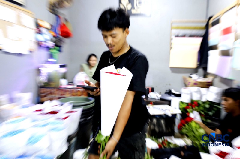 Pekerja menyelesaikan pengikatan bunga mawar di Pasar Rawa Belong, Jakarta, Kamis (12/2/2026). Permintaan bunga mawar mengalami peningkatan drastis menjelang perayaan hari Valentine pada 14 Februari 2026. (CNBC Indonesia/Tri Susilo)