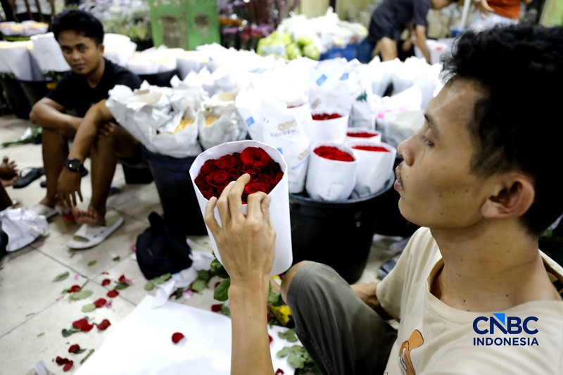 Pekerja menyelesaikan pengikatan bunga mawar di Pasar Rawa Belong, Jakarta, Kamis (12/2/2026). Permintaan bunga mawar mengalami peningkatan drastis menjelang perayaan hari Valentine pada 14 Februari 2026. (CNBC Indonesia/Tri Susilo)