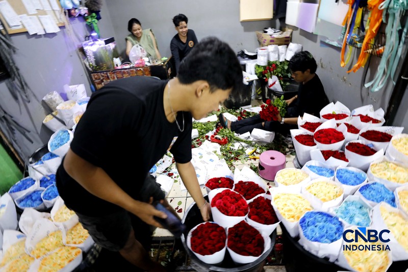 Pekerja menyelesaikan pengikatan bunga mawar di Pasar Rawa Belong, Jakarta, Kamis (12/2/2026). Permintaan bunga mawar mengalami peningkatan drastis menjelang perayaan hari Valentine pada 14 Februari 2026. (CNBC Indonesia/Tri Susilo)