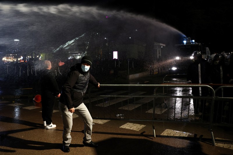 Para petugas polisi bereaksi terhadap bom molotov selama protes anti-pemerintah, yang dipicu oleh penyelidikan korupsi terhadap Wakil Perdana Menteri Belinda Balluku, di depan Gedung Parlemen di Tirana, Albania, 10 Februari 2026. (REUTERS/Florion Goga)