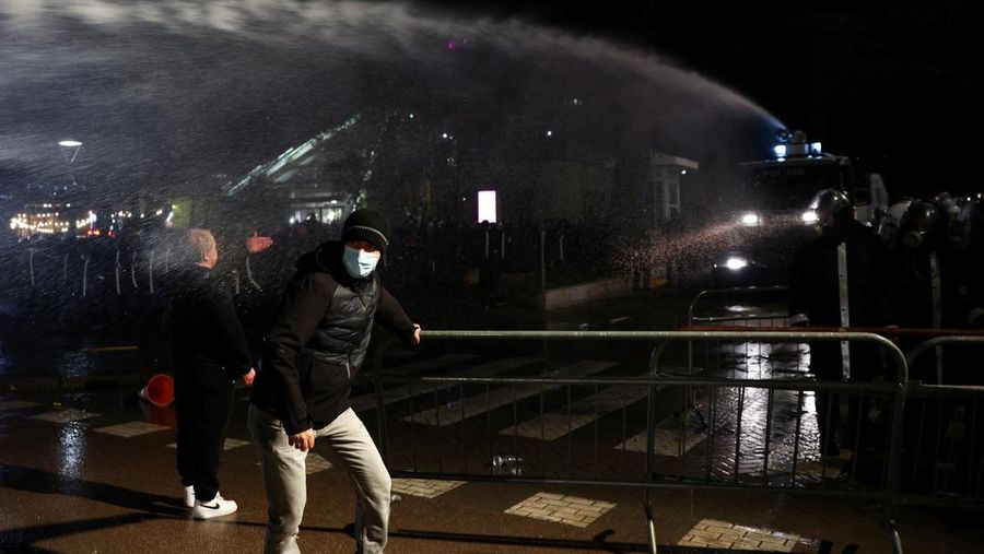 Para petugas polisi bereaksi terhadap bom molotov selama protes anti-pemerintah, yang dipicu oleh penyelidikan korupsi terhadap Wakil Perdana Menteri Belinda Balluku, di depan Gedung Parlemen di Tirana, Albania, 10 Februari 2026. (REUTERS/Florion Goga)