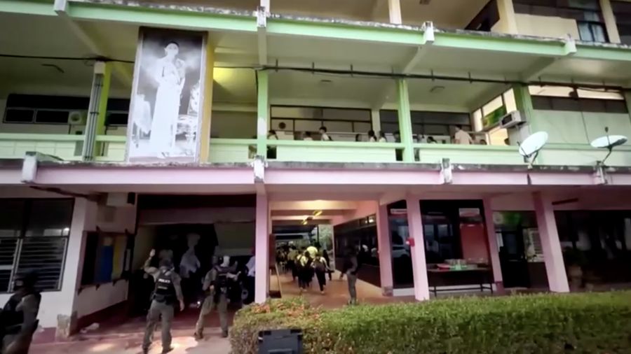 Sejumlah polisi bersenjata mengevakuasi pelajar saat pria bersenjata menyandera sejumlah siswa dan guru di Songkhla, Thailand selatan, 11 Februari 2026. (Reuters)