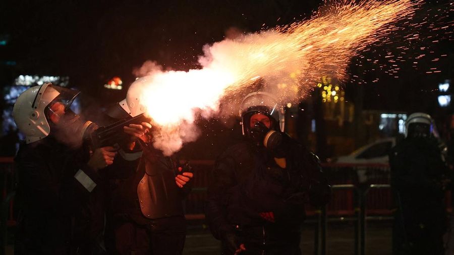 Para petugas polisi bereaksi terhadap bom molotov selama protes anti-pemerintah, yang dipicu oleh penyelidikan korupsi terhadap Wakil Perdana Menteri Belinda Balluku, di depan Gedung Parlemen di Tirana, Albania, 10 Februari 2026. (REUTERS/Florion Goga)
