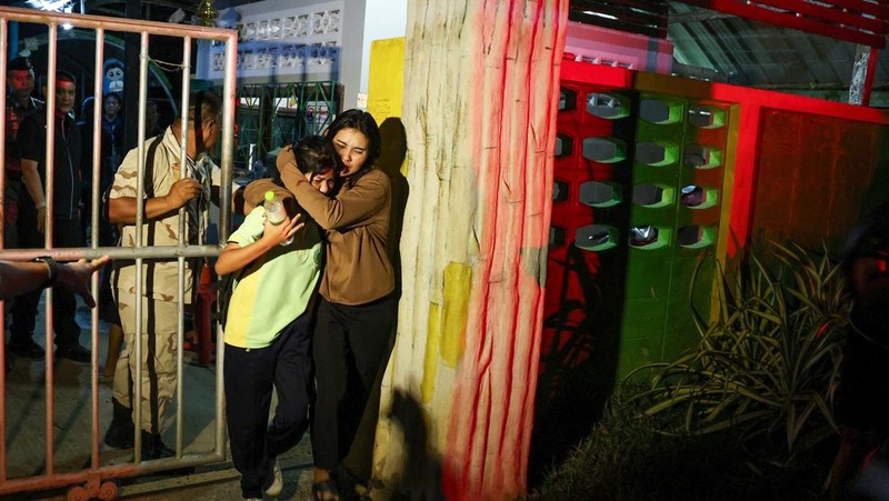 Sejumlah polisi bersenjata mengevakuasi pelajar saat pria bersenjata menyandera sejumlah siswa dan guru di Songkhla, Thailand selatan, 11 Februari 2026. (Reuters)