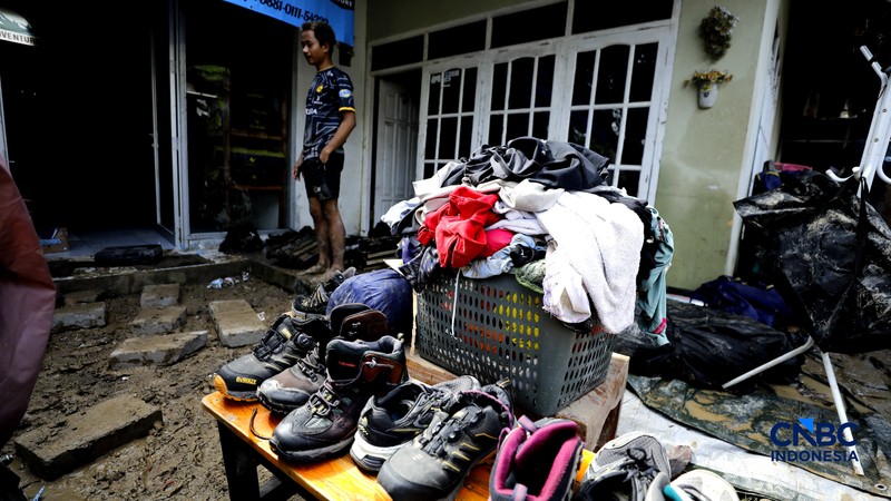 Warga membersihkan properti rumah yang terkena banjir di Kampung Carewed, Desa Cijayanti, Babakan Madang, Kabupaten Bogor, Jawa Barat, Kamis (12/2/2026). (CNBC Indonesia/Tri Susilo)