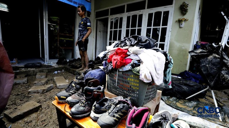 Warga membersihkan properti rumah yang terkena banjir di Kampung Carewed, Desa Cijayanti, Babakan Madang, Kabupaten Bogor, Jawa Barat, Kamis (12/2/2026). (CNBC Indonesia/Tri Susilo)