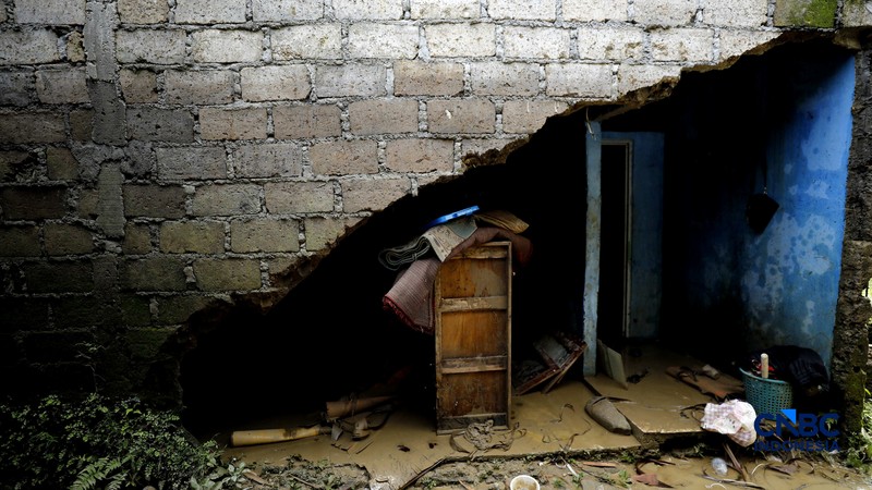 Warga membersihkan properti rumah yang terkena banjir di Kampung Carewed, Desa Cijayanti, Babakan Madang, Kabupaten Bogor, Jawa Barat, Kamis (12/2/2026). (CNBC Indonesia/Tri Susilo)