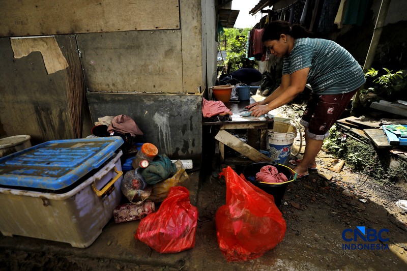 Warga membersihkan properti rumah yang terkena banjir di Kampung Carewed, Desa Cijayanti, Babakan Madang, Kabupaten Bogor, Jawa Barat, Kamis (12/2/2026). (CNBC Indonesia/Tri Susilo)