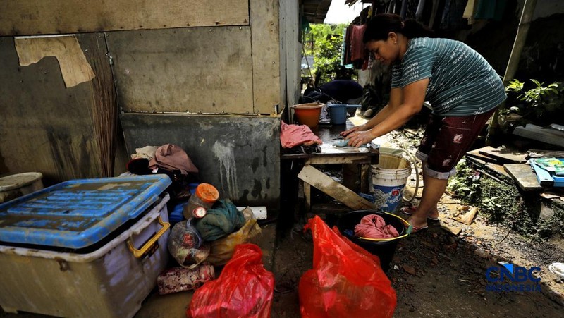 Warga membersihkan properti rumah yang terkena banjir di Kampung Carewed, Desa Cijayanti, Babakan Madang, Kabupaten Bogor, Jawa Barat, Kamis (12/2/2026). (CNBC Indonesia/Tri Susilo)