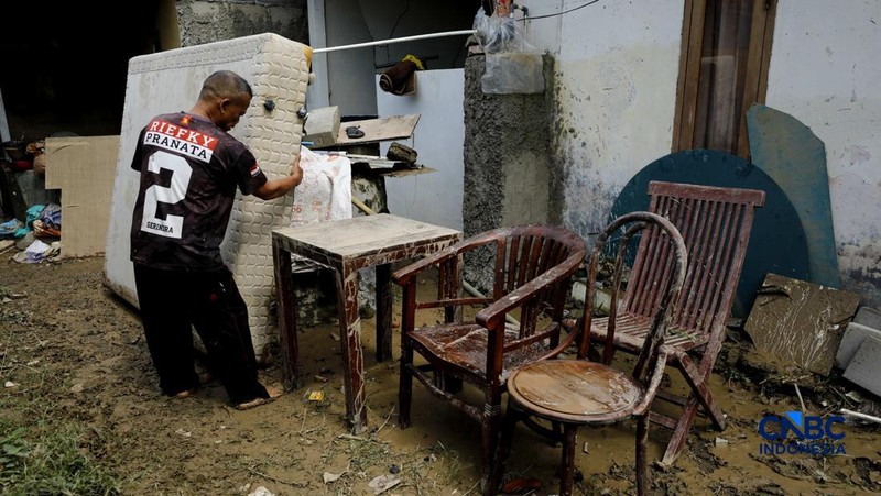 Warga membersihkan properti rumah yang terkena banjir di Kampung Carewed, Desa Cijayanti, Babakan Madang, Kabupaten Bogor, Jawa Barat, Kamis (12/2/2026). (CNBC Indonesia/Tri Susilo)